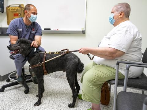 Doctor talking to dog owner before a free service dog eye exam