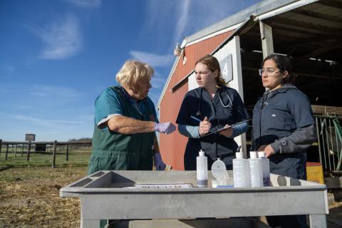 instructor with students on farm analyzing samples