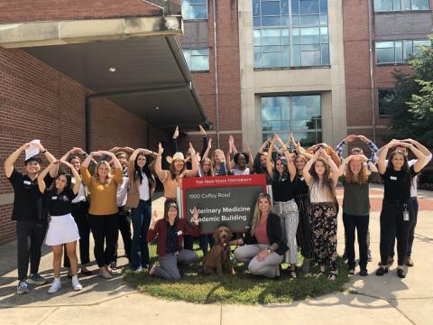 Students in front of VMAB sign doing O-H-I-O